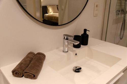 a bathroom sink with towels and a mirror at Pacific Residences - Studio in Antwerp
