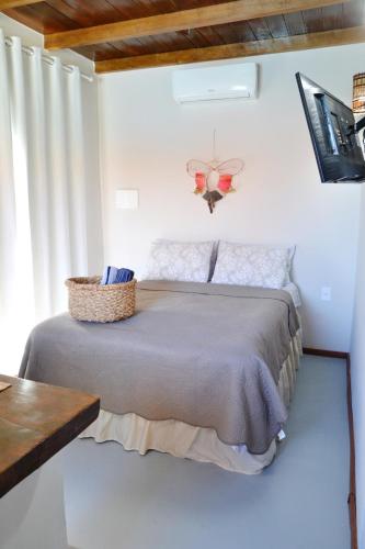 a bedroom with a bed in a white room at Chalés Cabocla da Lua in Caraíva