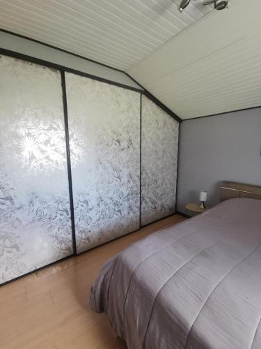 une chambre avec un grand lit et une fenêtre dans l'établissement Le Petit Rosnel, à Saint-Jean-de-Monts