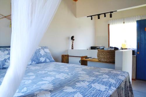 una camera con un letto e un piumone blu e bianco di Chalés Cabocla da Lua a Caraíva