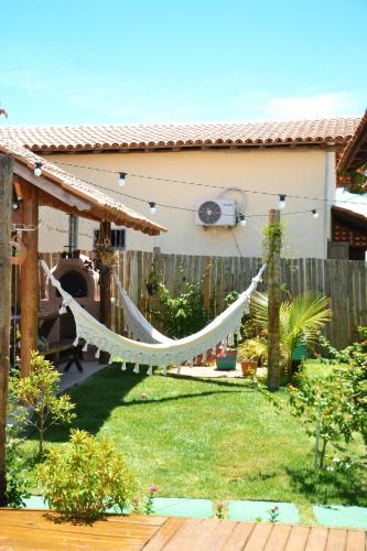 a hammock in the yard of a house at Chalés Cabocla da Lua in Caraíva