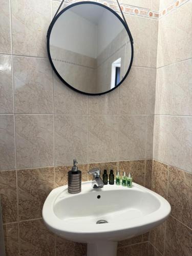 a bathroom with a sink and a mirror at O Mylos in Ermoupoli