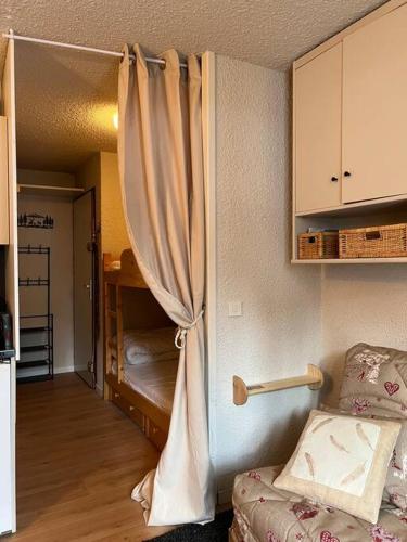 einen Vorhang in einem Zimmer mit einem Bett und einem Schlafzimmer in der Unterkunft Charmant studio Risoul 1850 in Risoul
