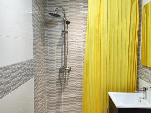 a bathroom with a shower with a yellow shower curtain at Dúplex en el centro de Córdoba in Córdoba