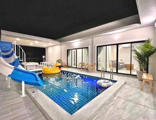 a living room with a pool with a slide and a house at GK Pool Villa in Ban Thap Tai (1)