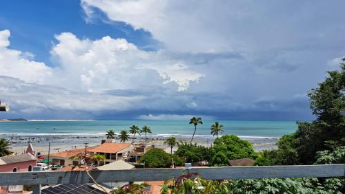 Blick auf einen Strand mit Palmen und das Meer in der Unterkunft Casa do Sol in Pipa