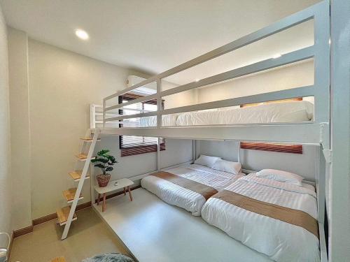a bedroom with two bunk beds and a staircase at GK Pool Villa in Ban Thap Tai (1)