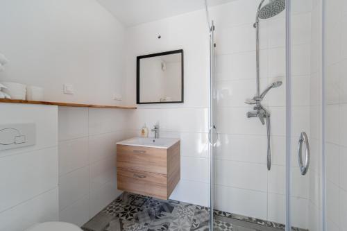 a bathroom with a glass shower and a sink at Babki z Piasku in Dziwnów