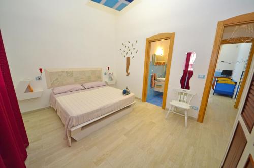 een slaapkamer met een bed en een stoel erin bij CASA MONDRIAN in Tiggiano