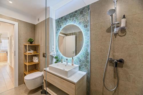 a bathroom with a sink and a shower with a mirror at B-Holiday Luxury Apartments Urban Plaza in Braşov