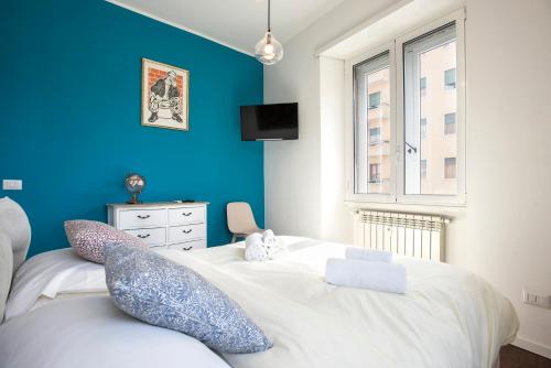 ローマにあるIl Principe, Elegant Family Apartment two bedroom near Colosseumの青い壁と大きな白いベッドのある寝室