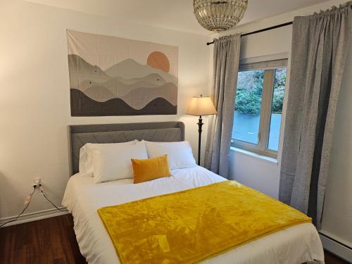 a bedroom with a bed with a yellow blanket on it at Cozy 1BR with Free Parking Downtown Conv Center in Seattle