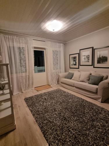 uma sala de estar com um sofá e uma janela em Beautiful townhouse, piece of luxury em Pori
