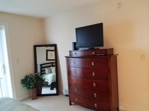 una camera da letto con TV sopra un comò di Corner suite at Peninsula Bay Resort awaits a Traverse City
