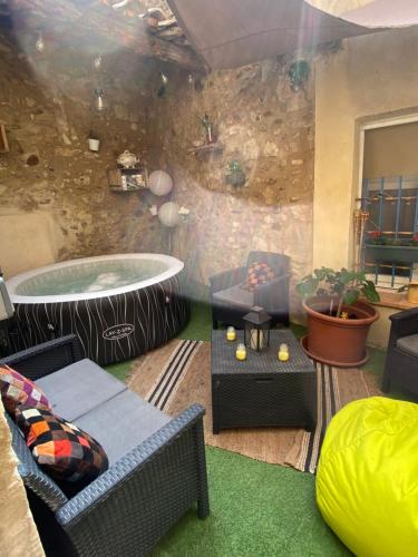 ein Wohnzimmer mit Whirlpool im Zimmer in der Unterkunft Logement atypique avec jacuzzi inclus in Mallemort