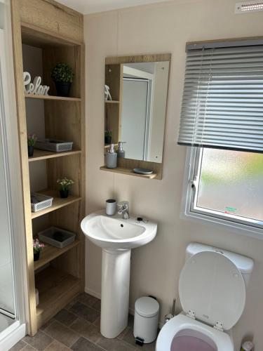 a bathroom with a sink and a toilet and a mirror at The Lay By in Prestonpans