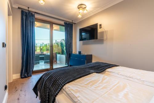 Góralski Resort Pool & SPA في بيالكا تاترزانسكا: غرفة نوم بسرير ونافذة كبيرة