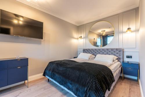 sypialnia z łóżkiem i lustrem na ścianie w obiekcie Góralski Resort Pool & SPA w mieście Białka Tatrzanska
