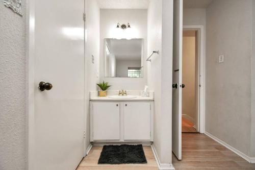 W białej łazience znajduje się umywalka i lustro. w obiekcie 5 Beds - 3 Bedrooms Near Galleria With Patio w mieście Houston