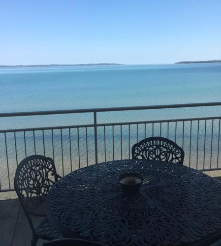 a table and chairs on a balcony overlooking the ocean at Beautiful views from Fifth Floor Suite in Traverse City