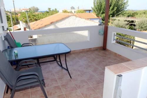 a small balcony with a blue table and chairs at Olympia's Sea Resort 1 in Mourteri