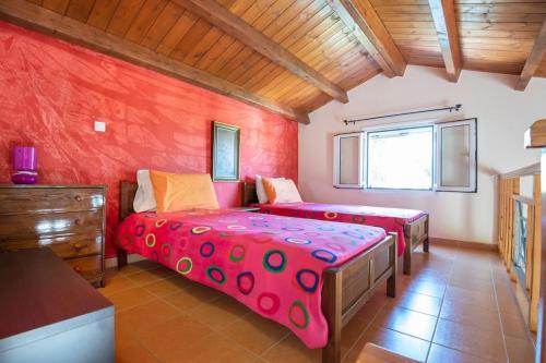 a bedroom with two beds and a red wall at Olympia's Sea Resort 1 in Mourteri