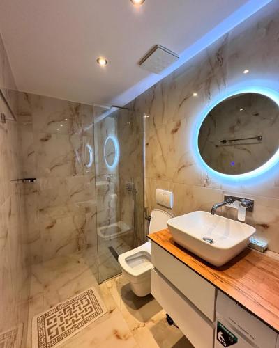 a bathroom with a sink and a shower and a toilet at Panoramic Views of Saranda in Sarandë