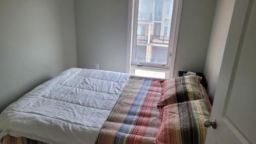 a bed in a room with a window at Modern 3 bedroom home in Brampton in Brampton