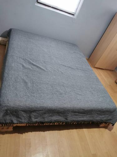 a grey blanket sitting on top of a floor at Cottage House Official in Niš