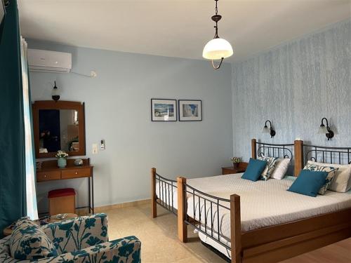 a bedroom with a bed with blue pillows and a couch at Actis studios 2 in Stelida