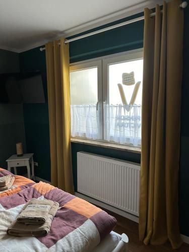 a bedroom with a bed and a window at Pension Victoria in Halberstadt