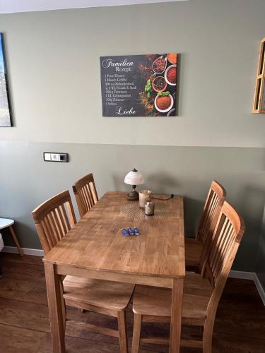 een houten tafel met stoelen en een bord met eten erop bij Pension Victoria in Halberstadt