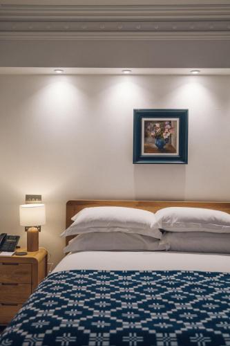 a bedroom with a bed and a picture on the wall at Portmeirion Village & Castell Deudraeth in Porthmadog