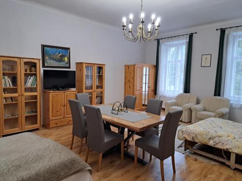 a dining room with a table and chairs and a television at Hanga Apartman, Kőszeg in Kőszeg