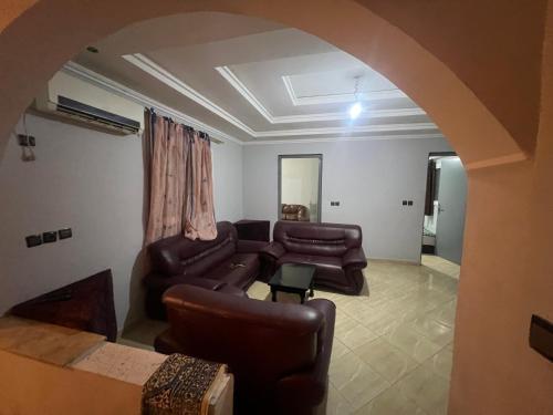uma sala de estar com mobiliário de couro e um arco em Appartement 5 en 2eme étage em Oujda