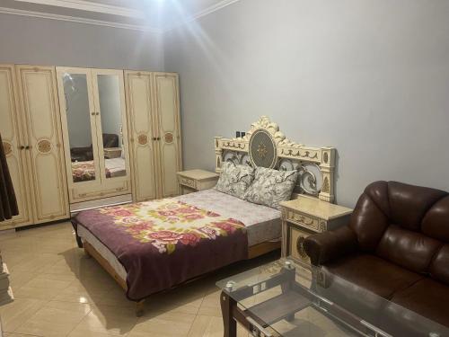 um quarto com uma cama, um sofá e uma cadeira em Appartement 5 en 2eme étage em Oujda