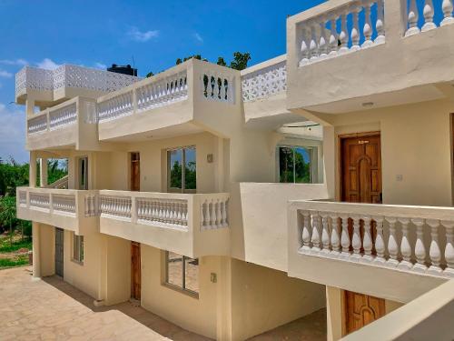un edificio con balcones blancos y escaleras. en SHIMBA SPRINGS MBUYU. ( Malindi), en Malindi