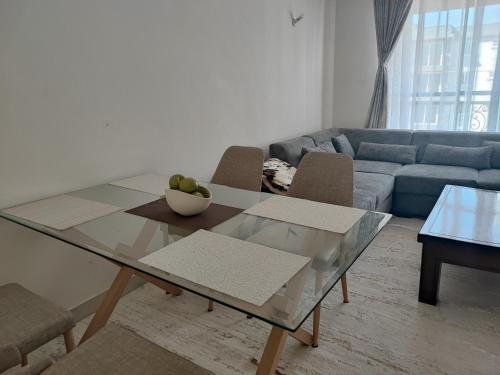 a living room with a glass table and a couch at Eden Homes - NEAR JKIA & SGR in Nairobi