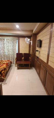 a room with a bed and a couch and a tv at Royal stay in Srinagar