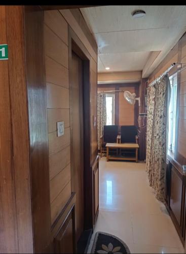 einen Flur mit Tür und ein Zimmer mit Stühlen in der Unterkunft Royal stay in Srinagar