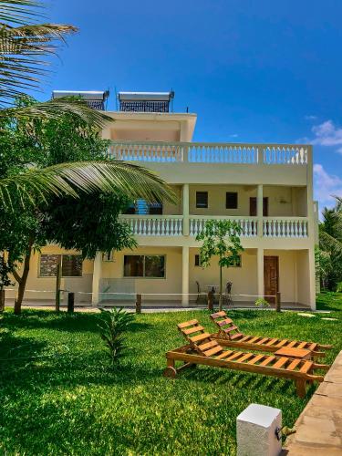 a house with a bench in front of it at SHIMBA SPRINGS MBUYU. ( Malindi) in Malindi