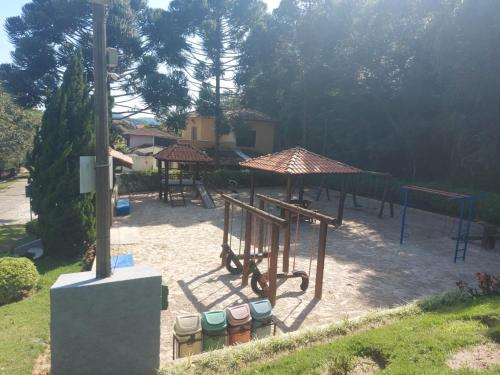 a park with a playground with tables and umbrellas at Chácara (Condomínio Portal dos Nobres- Atibaia/SP) in Atibaia