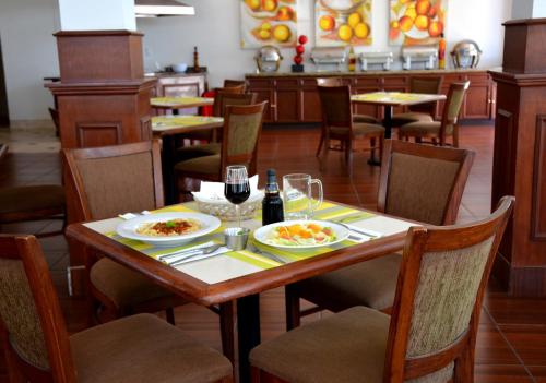 a table with two plates of food and a bottle of wine at Krystal Urban Ciudad Juarez by US Consulate in Ciudad Juárez