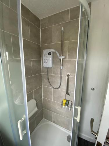 a shower with a glass door next to a bath tub at The Marlene - Lovely 3-Bed Home - Free WIFI & Parking - Short or Long Stays in Burton upon Trent