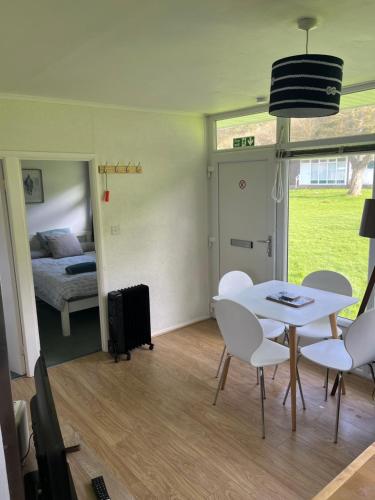 a room with a table and chairs and a bedroom at Chalet 77, Kings Chalet park,Cromer,North Norfolk. in Cromer