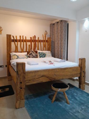 um quarto com uma cama em madeira e uma cabeceira em madeira em DOVENEST II Homes em Nairobi