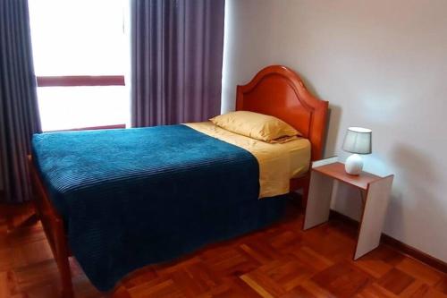 a bedroom with a bed and a table with a lamp at Estudio a estrenar en Miraflores in La Paz
