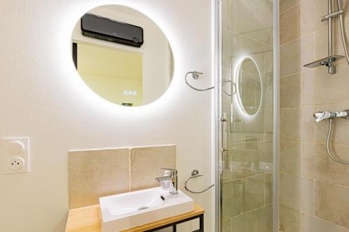 een badkamer met een wastafel en een douche met een spiegel bij Owl Right - C La Chouette in Dijon