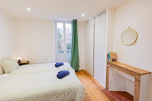 une chambre avec deux lits et un miroir dans l'établissement Owl Right - C La Chouette, à Dijon