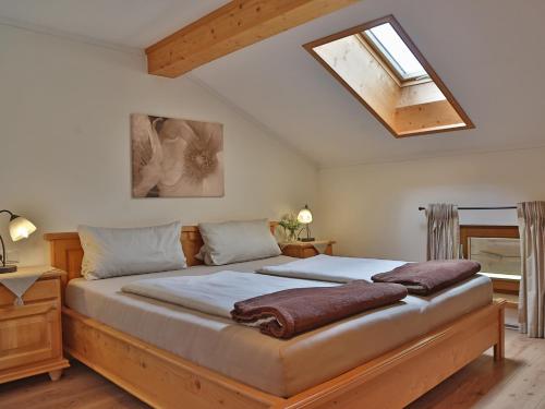 Schlafzimmer mit einem großen Bett und einem Dachfenster in der Unterkunft Sotterhof - Chiemgau Karte in Inzell